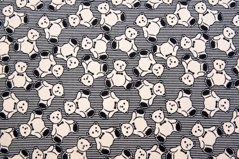 May include: Black and white fabric with a repeating pattern of teddy bears wearing bow ties. The bears are outlined in black and have a white interior.