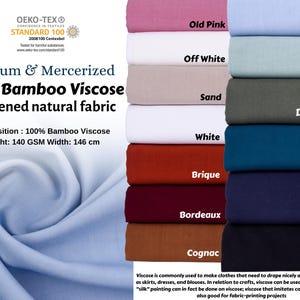 May include: A stack of 12 fabric swatches in various colors, including old pink, off white, sand, white, brique, bordeaux, cognac, old blue, old green, dark green, petrol, and navy. The fabric is 100% bamboo viscose, 140 GSM, and 146 cm wide. The fabric is soft and natural, and is ideal for draping and hanging loose. The fabric is also good for crafts, such as painting and fabric-printing projects.