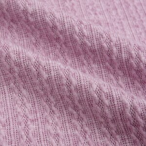 May include: Close-up of a soft, textured fabric in a light purple color. The fabric has a subtle, woven pattern.