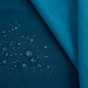K&ouml;nnte beinhalten: Nahaufnahme eines teal-farbenen Stoffes mit Wassertropfen. Der Stoff hat eine glatte, matte Oberfl&auml;che auf der einen Seite und eine strukturierte, fleeceartige Oberfl&auml;che auf der anderen Seite. Die Wassertropfen sind klar und kugelf&ouml;rmig.