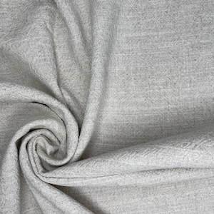 May include: A close-up of a gray fabric with a textured weave. The fabric is folded and draped, creating a soft, flowing look.