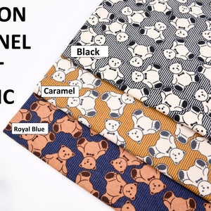 May include: Cotton flannel fabric with a teddy bear print in three colors: black, caramel, and royal blue. The fabric has a striped pattern.