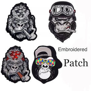 May include: Four embroidered patches featuring different styles of gorilla faces. Each patch has a different design, including a bandana, sunglasses, and a cap. The text "Embroidered Patch" is visible in the image.