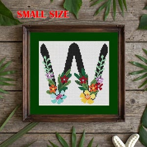 May include: A framed cross-stitch embroidery featuring the letter W in black, decorated with colorful floral and leaf patterns in red, yellow, blue, and green on a white grid background. The text SMALL SIZE is printed in red at the top.