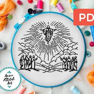 Op de afbeelding: Zwart-witte kruissteekpatroon van Jezus die naar de hemel opstijgt met een groep mensen eronder. Het patroon is op een witte stof met een blauwe borduurring.