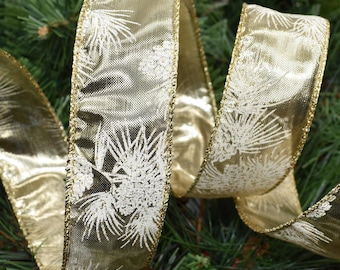 Könnte beinhalten: Goldenes Band mit weißem Kiefernadel- und Tannenzapfenmuster. Das Band hat einen metallischen Glanz und einen goldenen Rand. Geeignet für festliche Dekorationen oder Geschenkverpackungen.