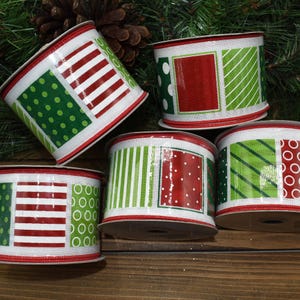 May include: A collection of decorative ribbon spools with a festive holiday theme. Each spool features a white background with red and green patterns, including stripes, polka dots, and squares. The edges are trimmed with red stitching, perfect for crafting and gift wrapping.