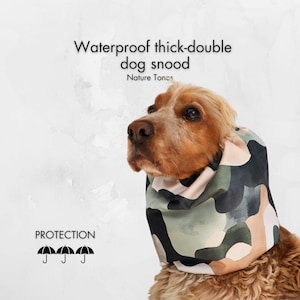 May include: A dog wearing a waterproof, thick, double dog snood with a camouflage pattern in shades of green, beige, and black. The text on the image reads "Waterproof thick-double dog snood" and "Nature Tones".