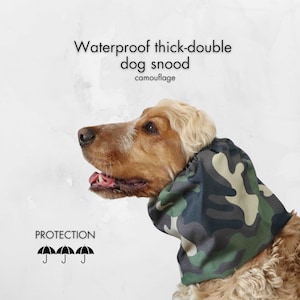 May include: A brown and white dog wearing a camouflage waterproof thick-double dog snood. The snood is designed to protect the dog's ears and neck from the elements. The text "PROTECTION" is printed below the dog's head with three umbrella icons.