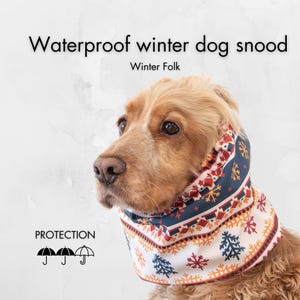May include: A golden Cocker Spaniel wearing a waterproof winter dog snood. The snood features a white background with a repeating pattern of snowflakes, trees, and geometric shapes in red, orange, and navy blue. Text on the image reads "Waterproof winter dog snood" and "Winter Folk."