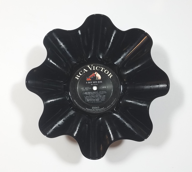 May include: A black, upcycled vinyl record bowl with a scalloped edge. The center label reads "RCA Victor A Date With Elvis". The bowl is a unique decorative item, perfect for holding small items.
