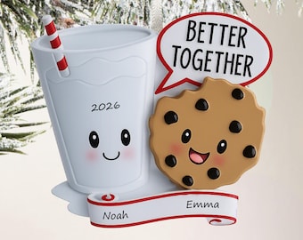 May include: A white glass of milk with a red and white striped straw, a smiling face, and the year 2026, paired with a smiling chocolate chip cookie. A red-outlined speech bubble reads BETTER TOGETHER, and a white banner displays the names Noah and Emma.