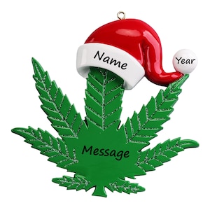 May include: Green marijuana leaf Christmas ornament with a red and white Santa hat on top. The ornament has the words "Name", "Year", and "Message" on it.