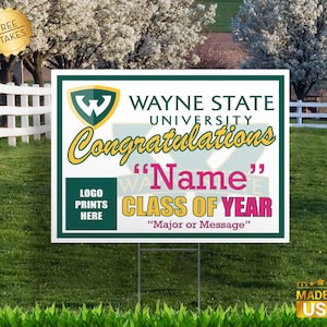 May include: A green and white yard sign with the Wayne State University logo and the text "Congratulations" in a gold script font. The sign also includes the text "Class of Year" in pink and the words "Name" and "Major or Message" in a smaller font.