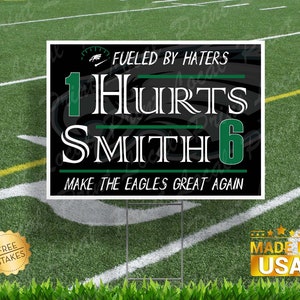 May include: Black and green yard sign with white text that reads "Fueled by Haters 1 Hurts Smith 6 Make the Eagles Great Again".