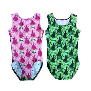 May include: Two sleeveless leotards. One is pink with a repeating pattern of a princess silhouette and the word "Munchkin". The other is green with a repeating witch silhouette pattern.