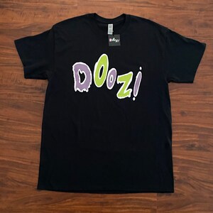 May include: Black t-shirt with a green and purple "DOOZI!" graphic print.