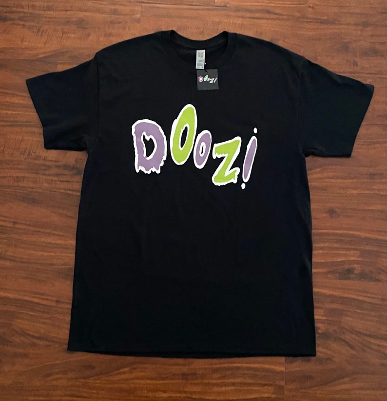 May include: Black t-shirt with a green and purple "DOOZI!" graphic print.