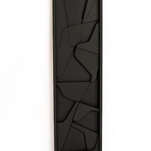 May include: Black framed wall art with a geometric design of overlapping shapes.