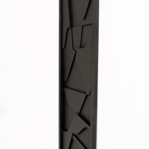 May include: Black framed wall art with a geometric design. The art is made of wood and has a 3D effect.
