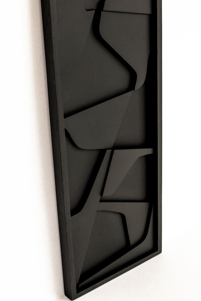 May include: Black wall art with a geometric design. The art is made of wood and has a 3D effect.