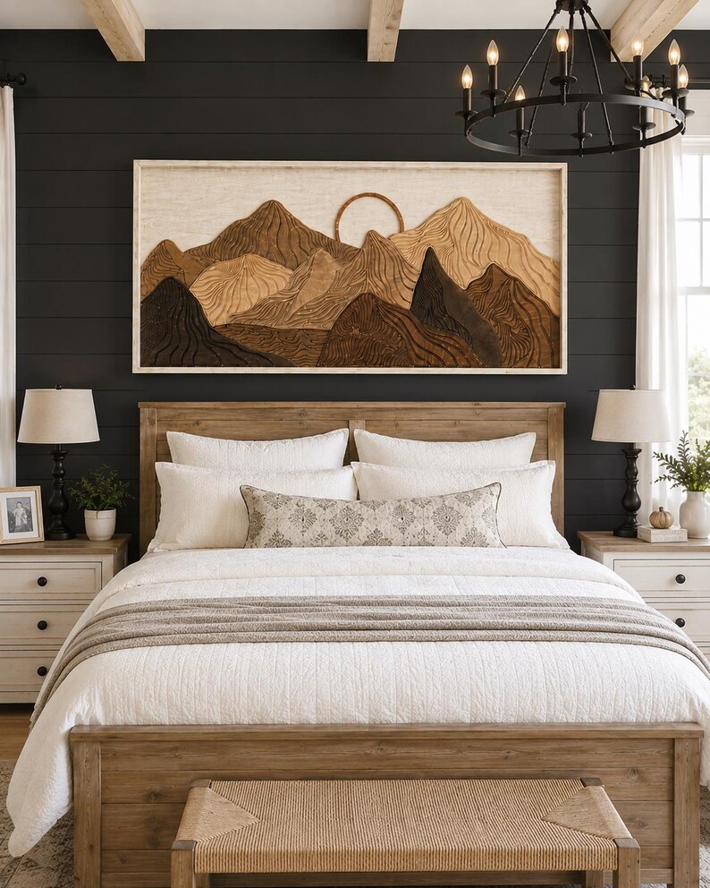 May include: A rectangular wall art piece featuring a layered wooden mountain landscape with a circular sun element, framed in light wood. The artwork displays various shades of brown and tan wood grain textures, mounted above a wooden bed frame.