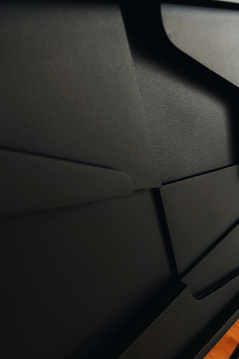 May include: Black wooden cabinet with geometric design and multiple drawers. The cabinet has a textured finish and is made of solid wood.