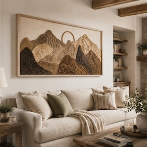May include: A rectangular wall art piece featuring a layered wooden mountain landscape with a circular sun element. The artwork displays various shades of brown, tan, and cream, with carved vertical lines creating texture across the mountain peaks.