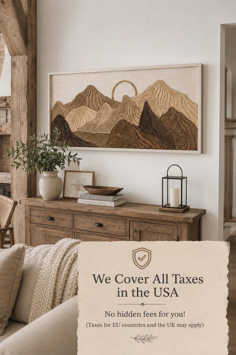 May include: A rectangular wall art piece featuring a layered wooden mountain landscape with a circular sun element, framed in a light-coloured wood border. The artwork displays varying shades of brown and tan wood with carved, wavy textures.