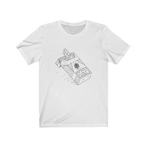 Può includere: Una t-shirt bianca a maniche corte con un'illustrazione a linee nere di un pacchetto di sigarette aperto. Il pacchetto presenta un piccolo emblema circolare e il testo "Self obsession can make you miserable." centrato sulla parte del petto.