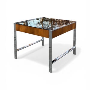 May include: A white ceramic mug with a black handle and the text "But First, Coffee" in a black, handwritten-style font. The mug is on a white surface.