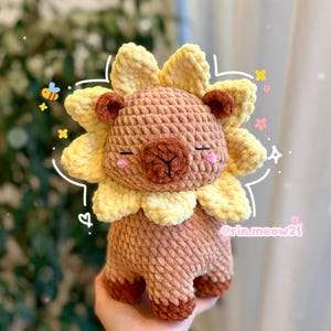 Peut inclure: Peluche lion en crochet, aux couleurs marron et jaune. Le lion a une crinière touffue, les yeux fermés et une expression douce. Ce jouet en peluche fait main est doux et câlin, idéal pour une chambre d'enfant ou comme objet décoratif.