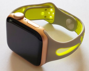 May include: A gold Apple Watch with a gray and yellow sport band. The band has a perforated design.