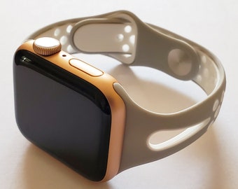 May include: A gold Apple Watch with a white sport band. The band has a perforated design for breathability.