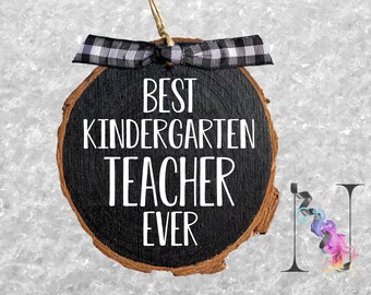 May include: A black and brown wooden ornament with a white ribbon and the text "Best Kindergarten Teacher Ever".