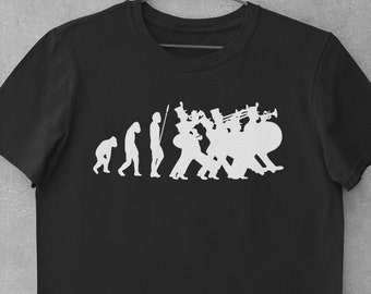Puede incluir: Camiseta negra con una silueta blanca de la evolución del hombre que termina con una banda de música.