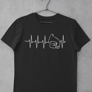 Pode incluir: Camiseta preta com um gráfico branco de um toca-discos vintage com uma linha de batimento cardíaco.