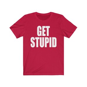 May include: Red short-sleeved t-shirt with white text that reads "GET STUPID".