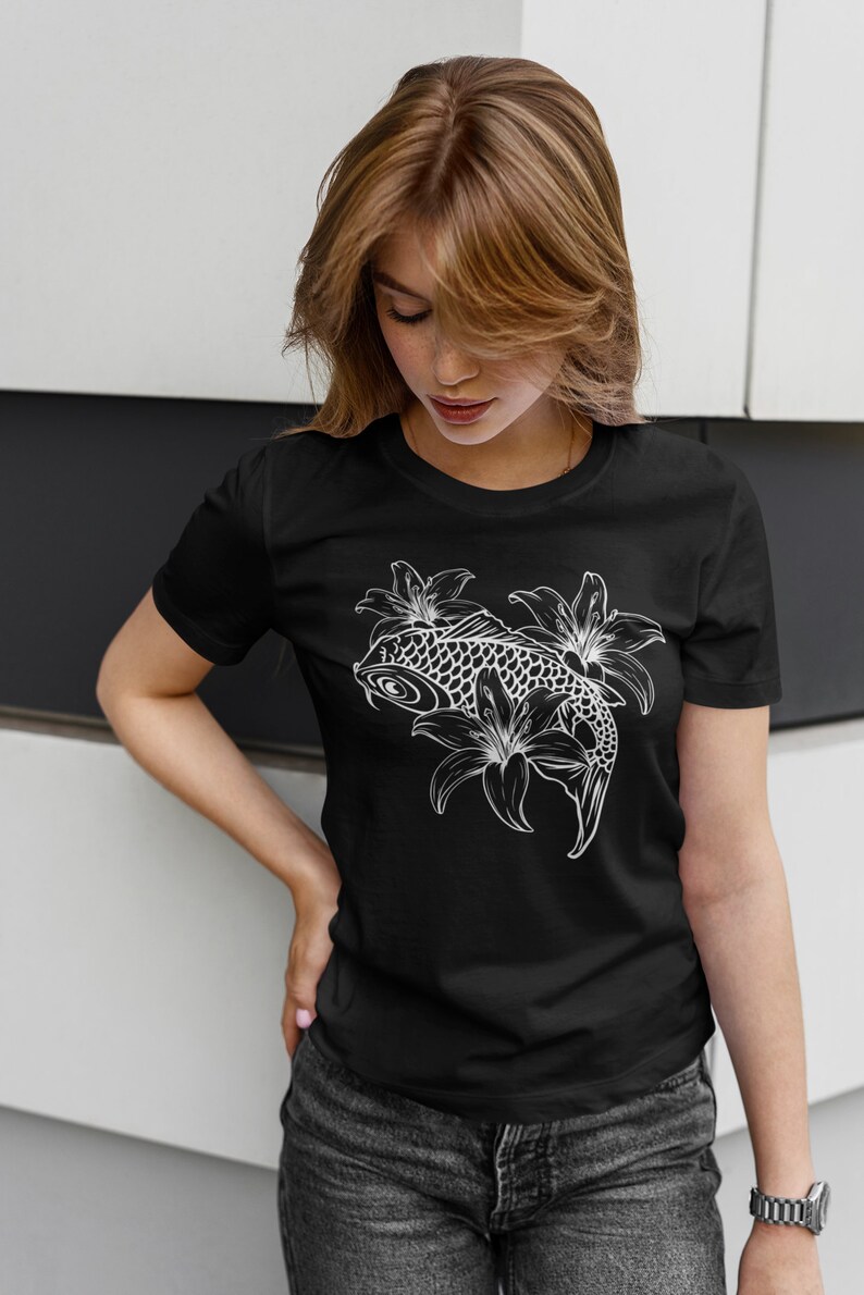 May include: A black t-shirt with a white graphic of a koi fish swimming through lilies.