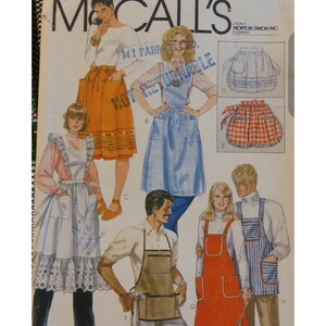 May include: A vintage sewing pattern featuring eight different apron designs. The aprons are in various styles and colors, including a white apron with lace trim, a blue gingham apron, and a red and white checkered apron.
