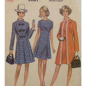 May include: Vintage sewing pattern featuring three illustrated women's fashion designs. The designs include a blue patterned coat dress, a blue patterned dress, and an orange coat with white lace trim. The word "EASY" is visible at the top.