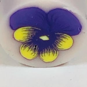 May include: A purple and yellow hand-painted flower with a white background. The flower has five petals, with the two top petals forming a heart shape.