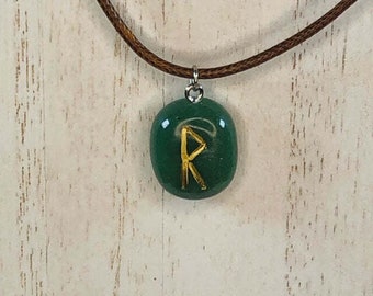 May include: A green stone pendant with a gold rune symbol on a brown leather cord necklace.