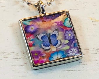 Handmade Polymer Clay and Resin Floral and Blue Butterfly Pendant - Silver Bezel Setting