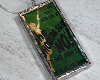 May include: A green glass pendant with a silver frame. The pendant features a vintage illustration of a woman with the text "HOW BAD CAN A GOOD GIRL GET SHE SHOULD'VE SAID NO! BUT SHE DIDN'T SAY NO OR STAY HOME".