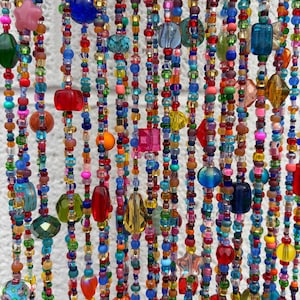 May include: A beaded curtain featuring multiple vertical strands of multicolored glass and plastic beads in various shapes, including spheres, cubes, stars, and teardrops, creating a vibrant, dense, and textured hanging display.