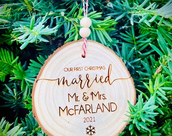 May include: A wooden Christmas ornament with the text "Our First Christmas married Mr. & Mrs. MCFARLAND 2021" and a snowflake.