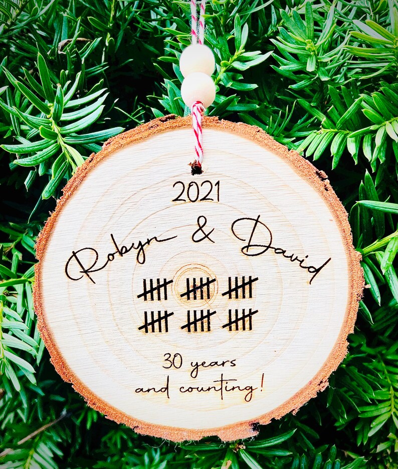 May include: A wooden ornament with the text "2021 Robyn & David" and "30 years and counting!" with tally marks representing 30 years.