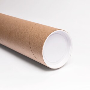 May include: A brown cardboard tube with a white plastic end cap. The tube is used for shipping posters or other rolled items.
