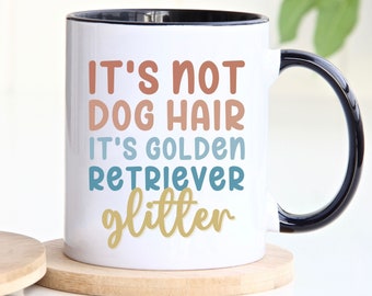 May include: White ceramic coffee mug with a black handle and rim. The mug has a colorful graphic that reads "It's not dog hair it's golden retriever glitter".